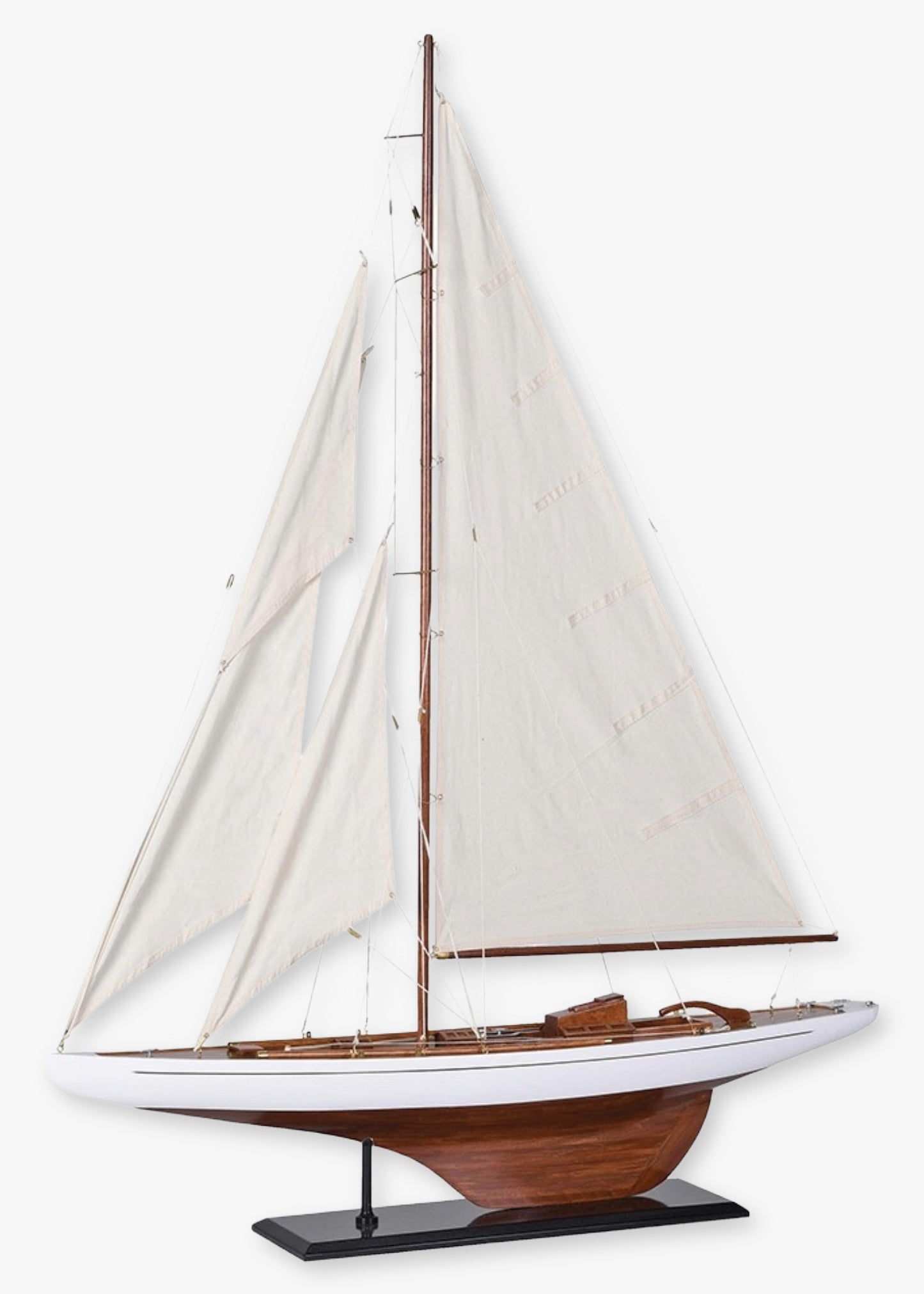 Model sailboat with white sails and varnished hull