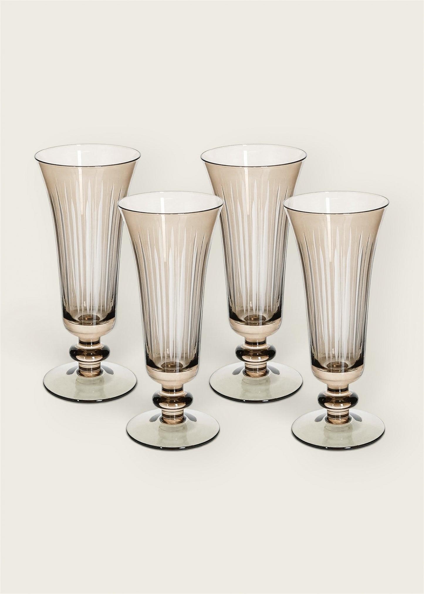 Four flared stemware glasses with a smoky translucent finish and vertical ribbing